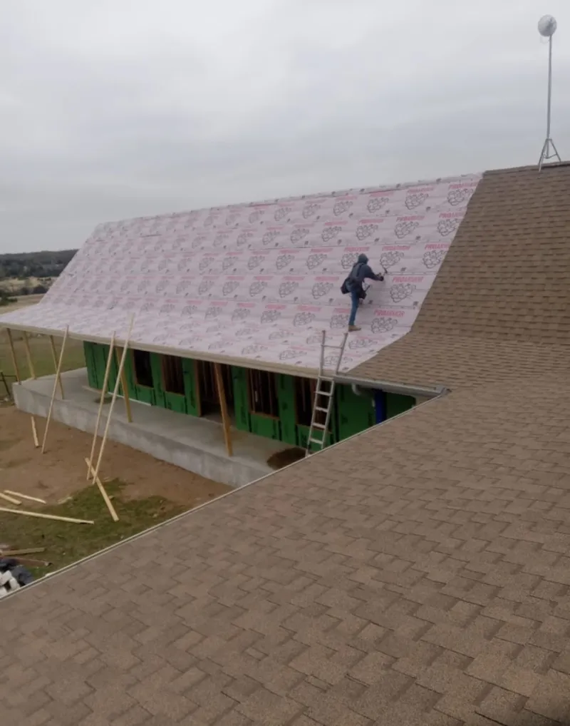 Worker preparing underlayment for a metal roof installation in Fair Oaks